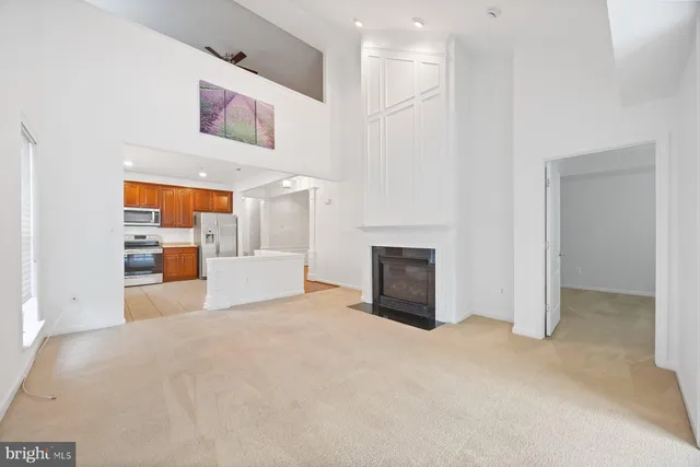 a view of an empty room with a fireplace and a window