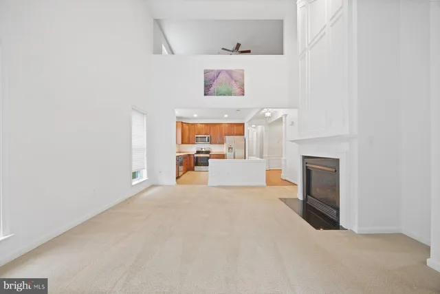 a view of an empty room with a fireplace and a window