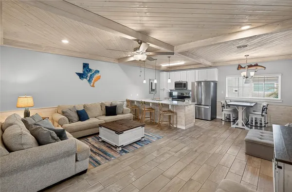 a living room with furniture kitchen view and a chandelier