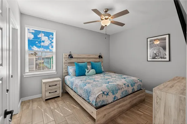 a bedroom with a bed a wall painting and a window