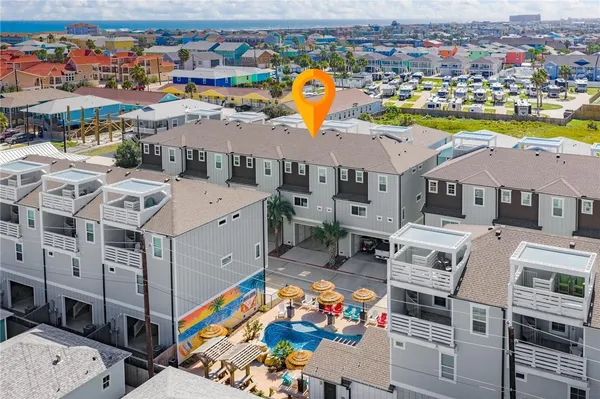 an aerial view of residential houses with outdoor space and parking