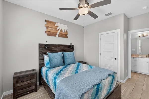 a bedroom with a large bed and a chandelier
