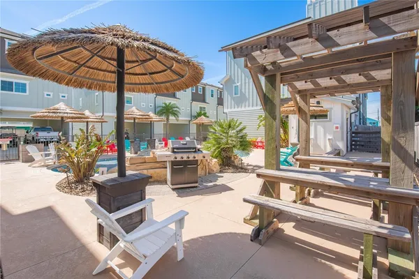 a view of a patio with a table and chairs under an umbrella