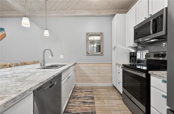 a kitchen with stainless steel appliances granite countertop a sink and stove top oven