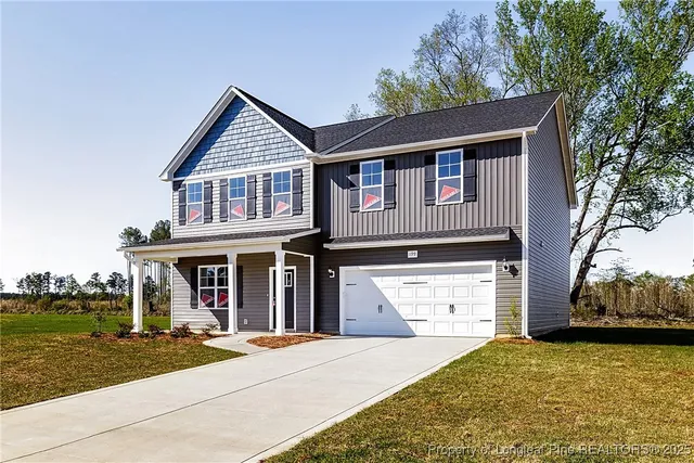 a front view of a house with a yard and garage