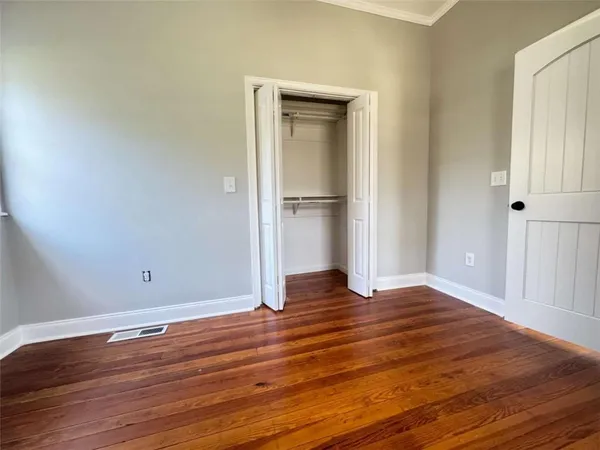 a view of empty room with wooden floor