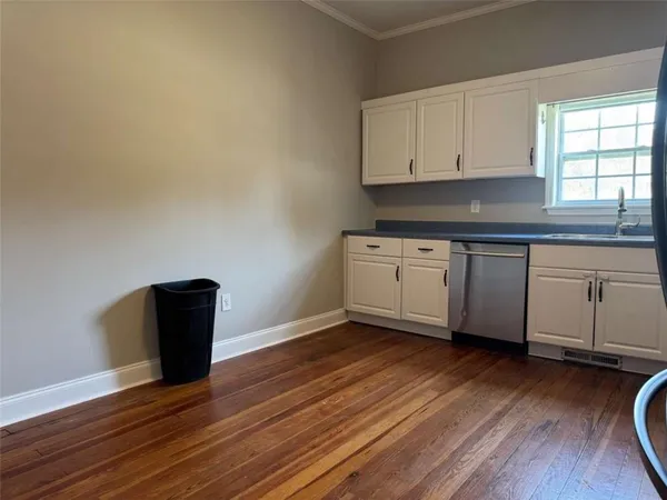 a kitchen with granite countertop appliances a sink cabinets and wooden floor