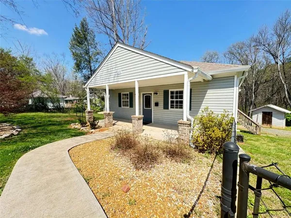 a view of a house with backyard and sitting area