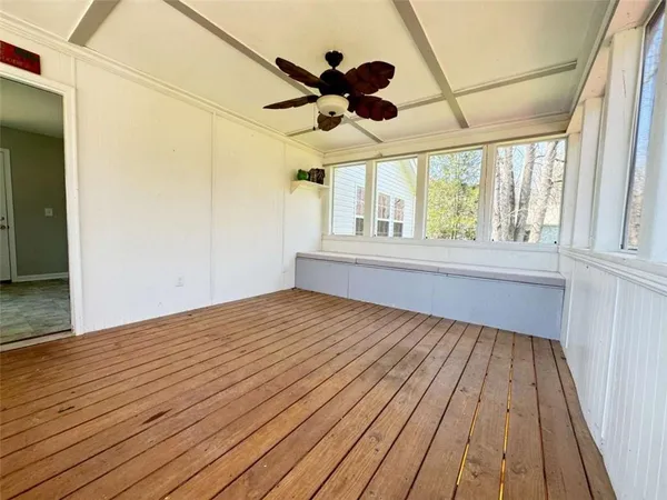 a view of a room with a ceiling fan and window