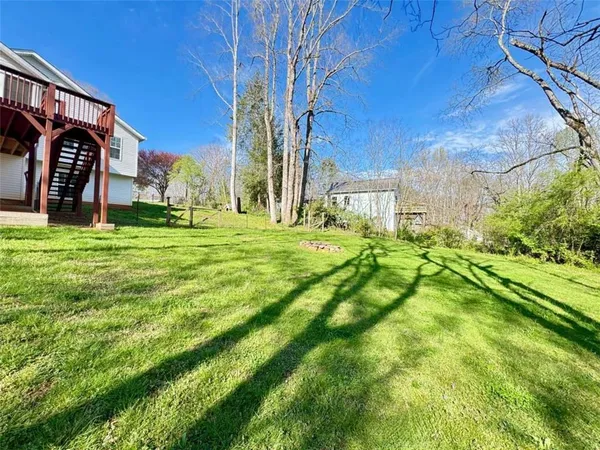 a view of a house with big yard and a large tree