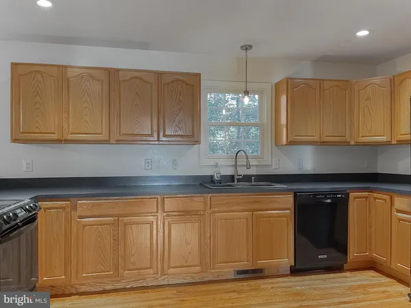 a large kitchen with granite countertop a large counter top stainless steel appliances and cabinets