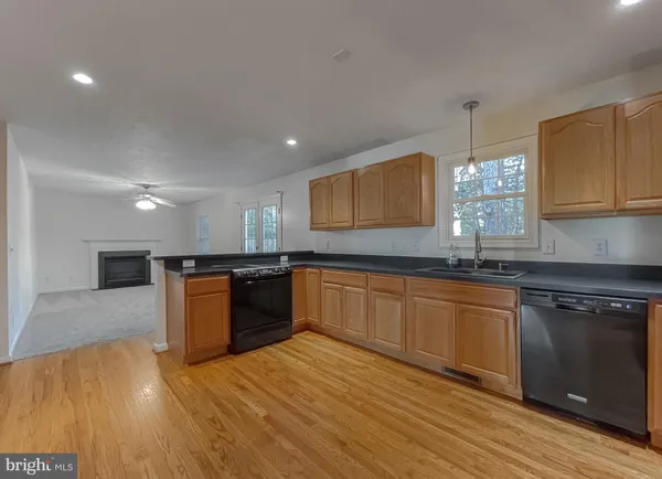 a view of kitchen with granite countertop stove top oven and sink