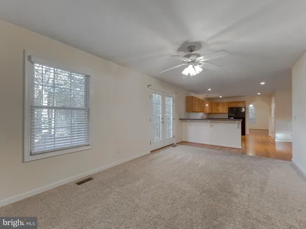an empty room with a ceiling fan and a fireplace