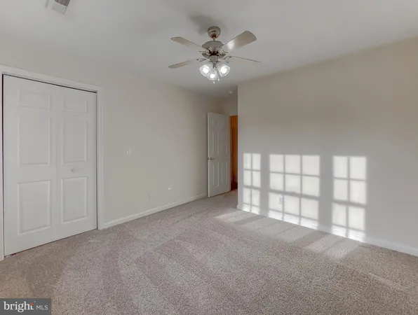 a view of a livingroom with an empty space and a ceiling fan