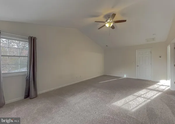 a view of a livingroom with a ceiling fan and window