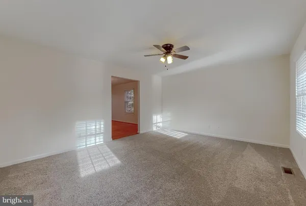 a view of a room with a ceiling fan and a window