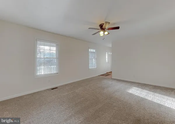a view of a livingroom with a ceiling fan and window