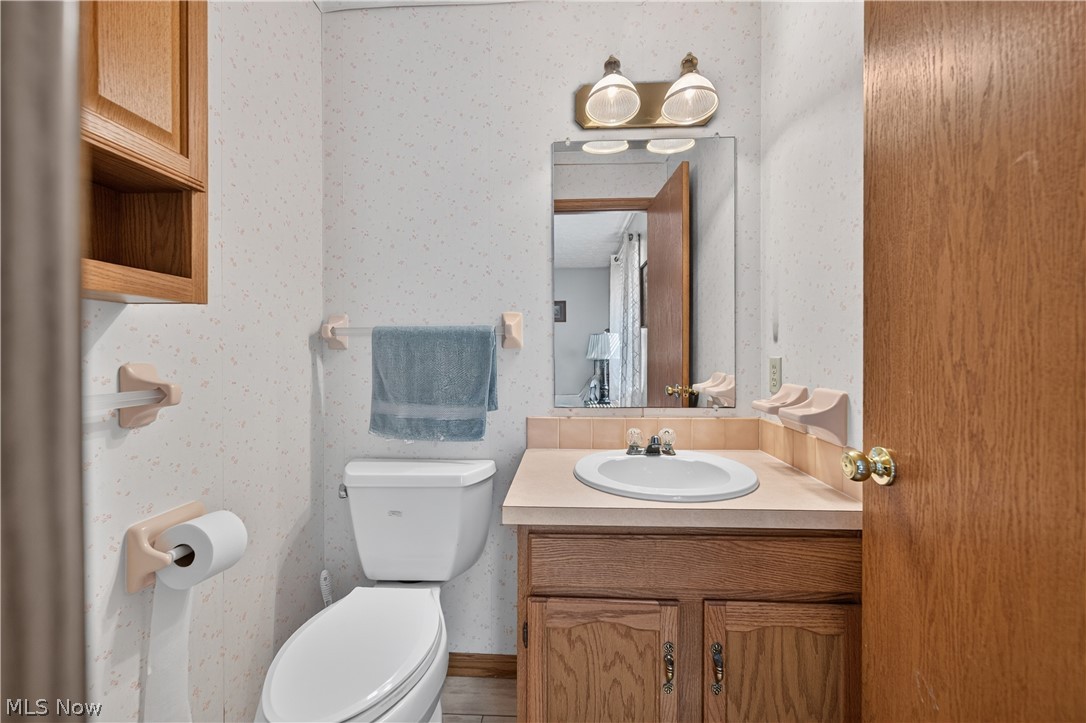 763 Lockwood Road Barberton, OH 44203 - Photo 19 of 24 Vanity with an integrated sink, wood-finish cabinetry, wall-mounted mirror, and overhead lighting