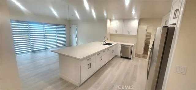 a kitchen with a sink and wooden floor