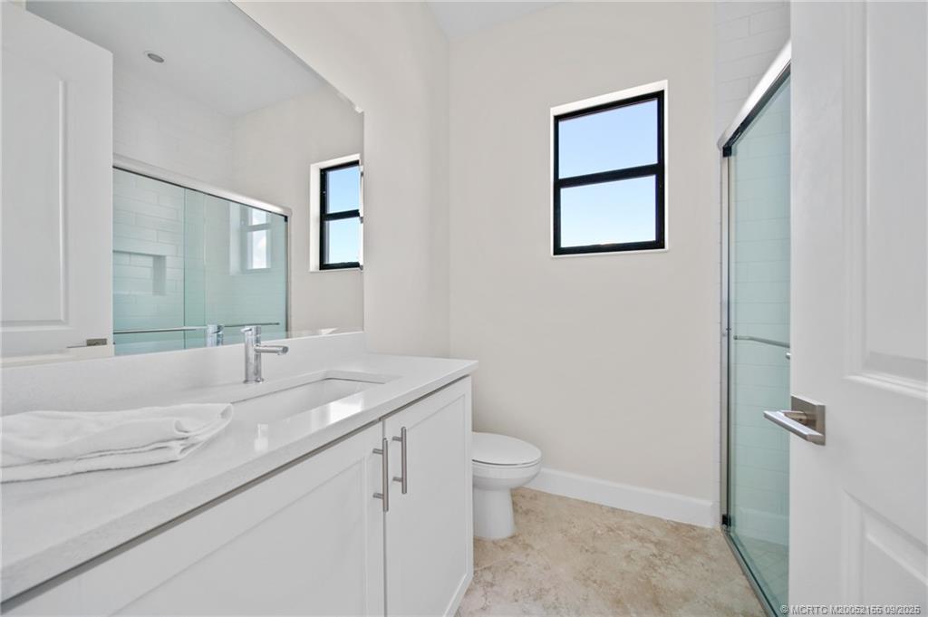 3654 Southwest Magnolia Ridge Lane Palm City, FL 34990 - Photo 14 of 23 a bathroom with a granite countertop sink toilet and mirror