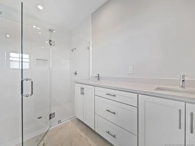 a bathroom with a shower sink and mirror