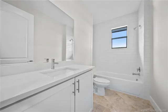 a bathroom with a granite countertop sink a toilet and a bathtub