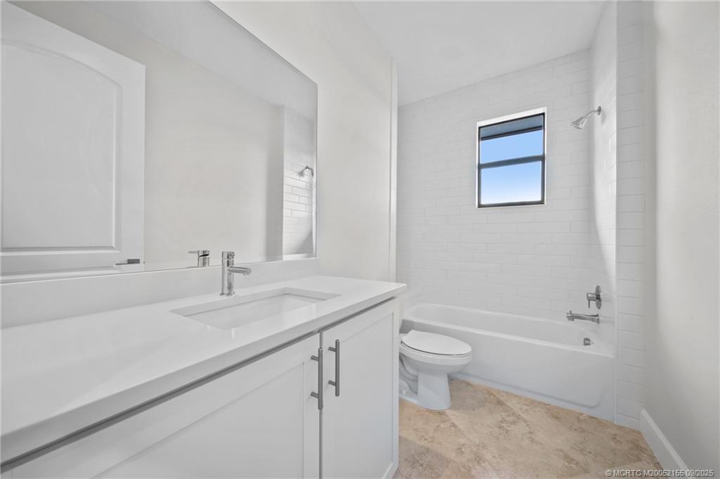 3654 Southwest Magnolia Ridge Lane Palm City, FL 34990 - Photo 20 of 23 a bathroom with a granite countertop sink a toilet and a bathtub