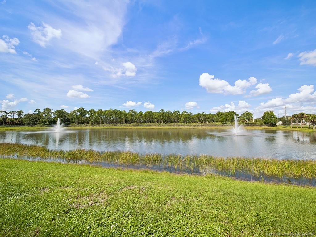 3654 Southwest Magnolia Ridge Lane Palm City, FL 34990 - Photo 6 of 23 a view of a lake with a building in the background
