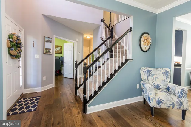 a view of front door with wooden floor and stairs