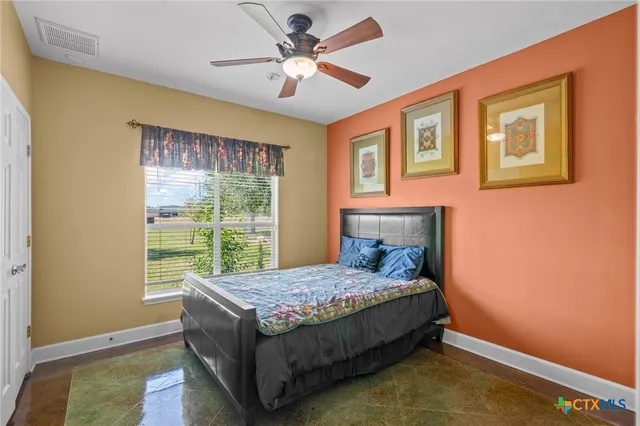 a bed sitting in a spacious bedroom next to a window