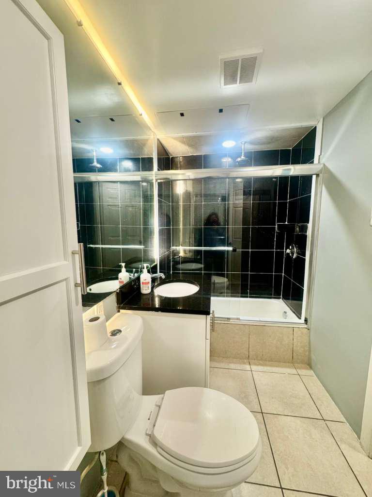 9278 Adelphi Road, Unit 103 Hyattsville, MD 20783 - Photo 20 of 24 a bathroom with a toilet a sink and shower