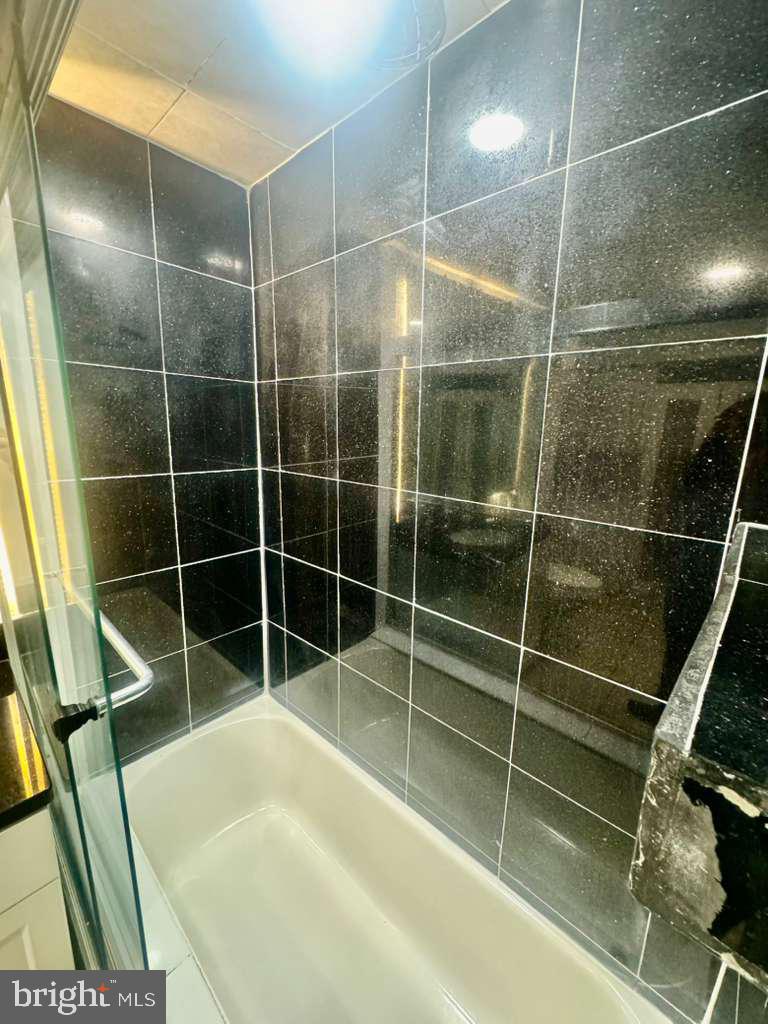 9278 Adelphi Road, Unit 103 Hyattsville, MD 20783 - Photo 21 of 24 a bathroom with a shower and a sink