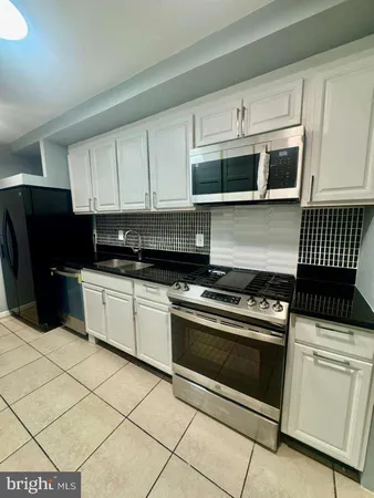 a kitchen with stainless steel appliances a stove a microwave and a sink