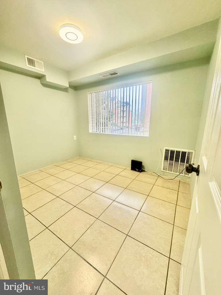 9278 Adelphi Road, Unit 103 Hyattsville, MD 20783 - Photo 9 of 24 a bedroom with a bed and a window in it