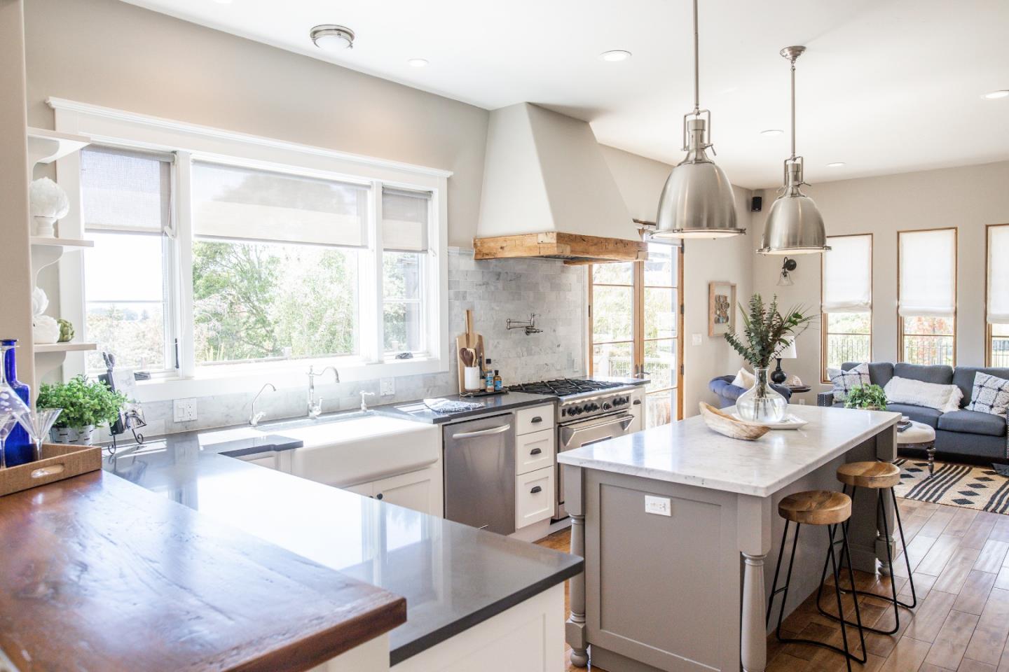 3430 Merrill Road Aptos, CA 95003 - Photo 8 of 49 a kitchen with stainless steel appliances granite countertop a stove a sink a oven a dining table with chairs and white cabinets next to a window