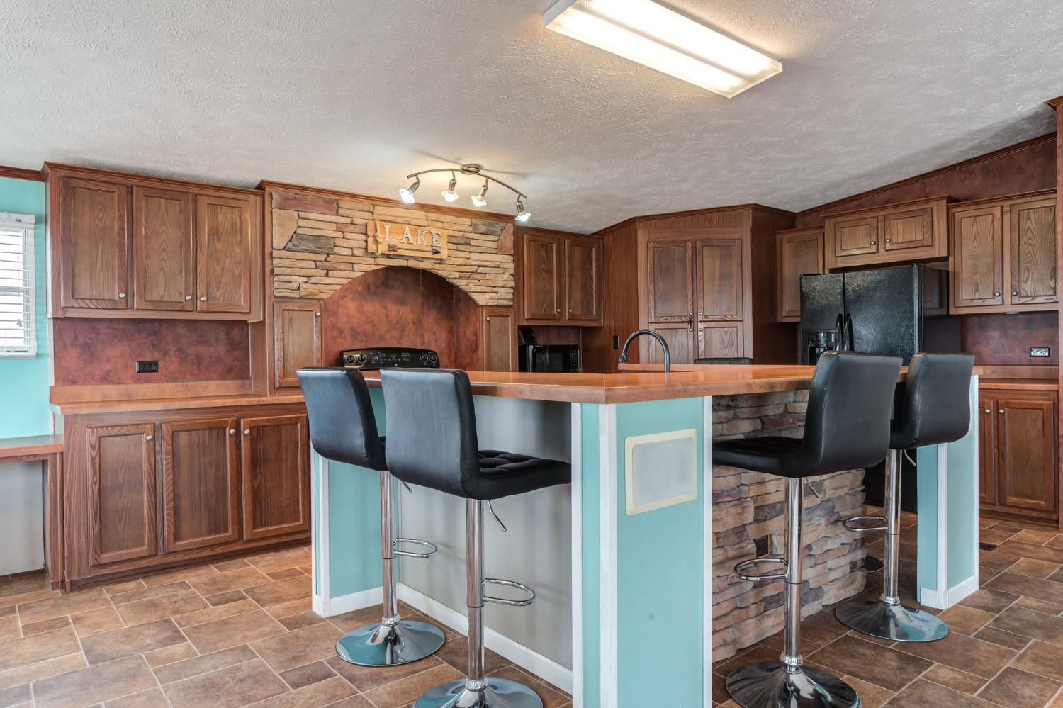 2446 Turkey Ridge Justiceburg, TX 79330 - Photo 16 of 50 a kitchen with a table chairs refrigerator and cabinets