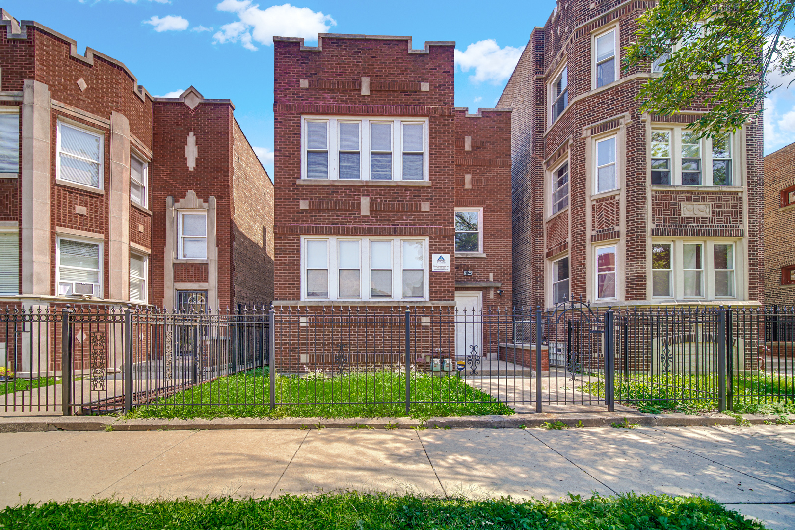 a view of a brick building next to a yard