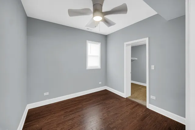 an empty room with wooden floor a ceiling fan and closet