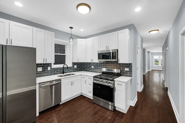 a kitchen with white cabinets and white appliances
