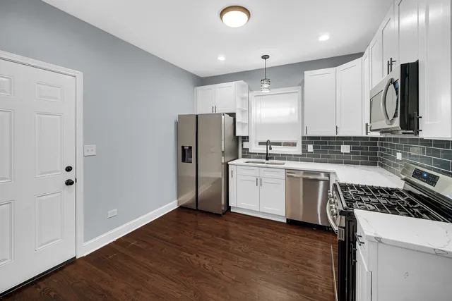 a kitchen with a refrigerator sink and cabinets