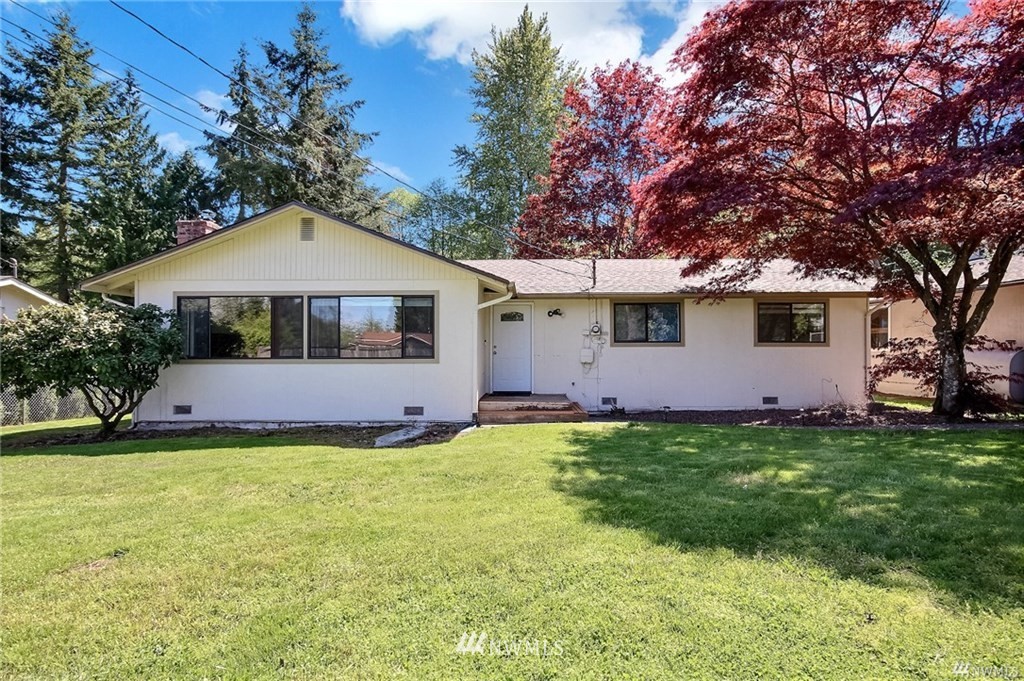 a view of a house with a yard and a tree