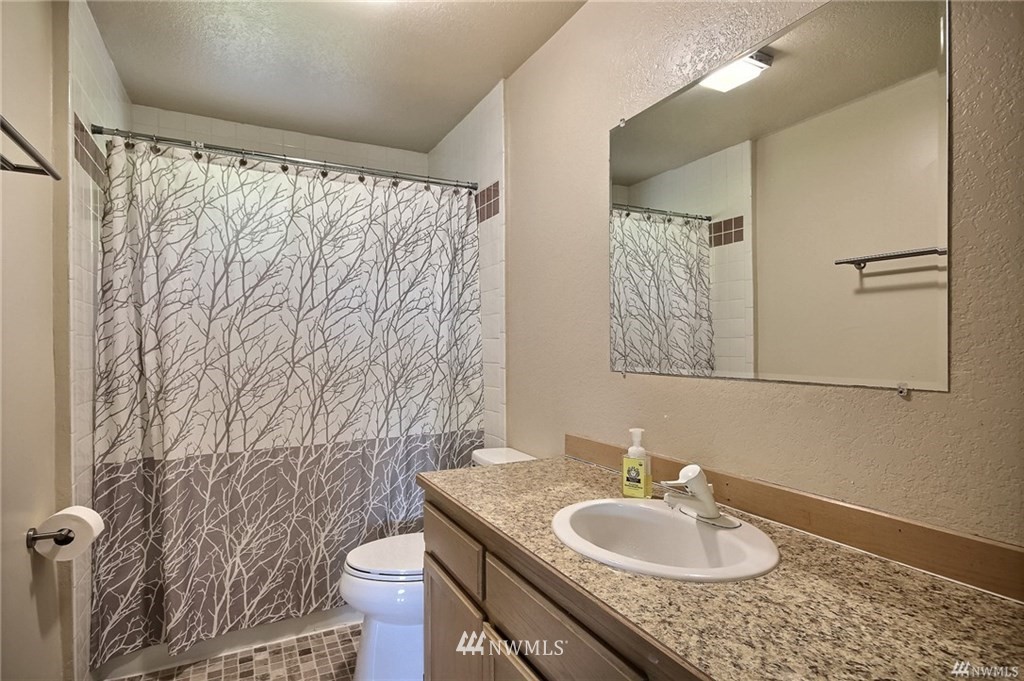 508 228th Street Southeast Bothell, WA 98021 - Photo 14 of 22 a bathroom with a granite countertop sink toilet and a mirror