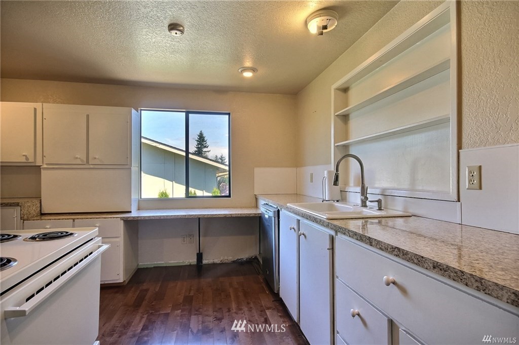 508 228th Street Southeast Bothell, WA 98021 - Photo 3 of 22 a kitchen with a sink cabinets and wooden floor
