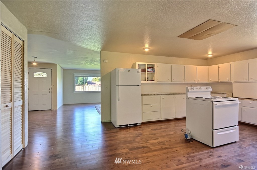 508 228th Street Southeast Bothell, WA 98021 - Photo 4 of 22 a kitchen with a refrigerator a stove top oven and wooden floor