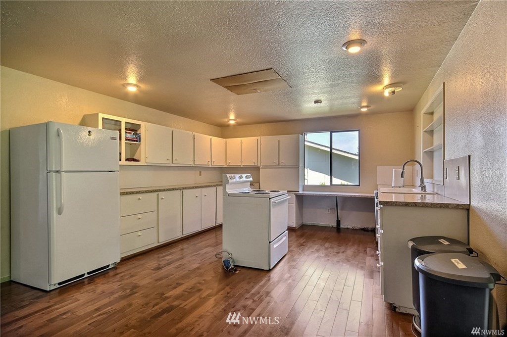 508 228th Street Southeast Bothell, WA 98021 - Photo 5 of 22 a kitchen with a refrigerator and white cabinets