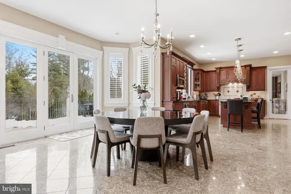 a kitchen with stainless steel appliances kitchen island granite countertop a table chairs and a sink