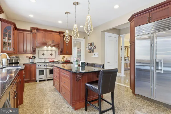 a kitchen with stainless steel appliances granite countertop a sink a stove and a wooden cabinets