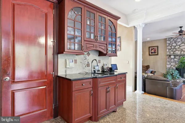 a bathroom with a granite countertop toilet a sink a shower and a window