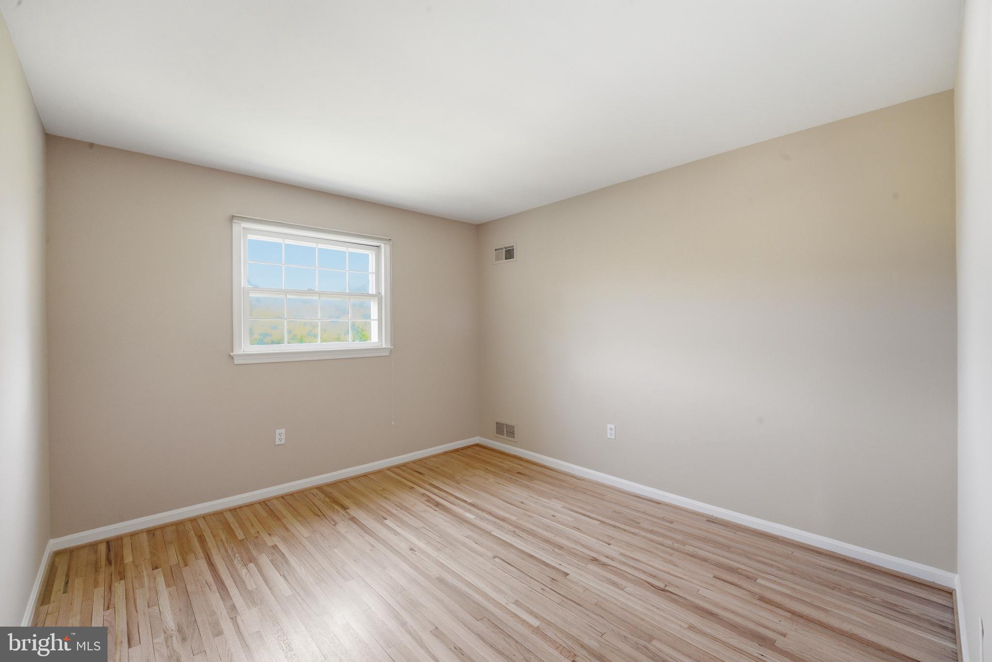 13309 Old Forge Road Silver Spring, MD 20904 - Photo 41 of 52 an empty room with wooden floor and windows