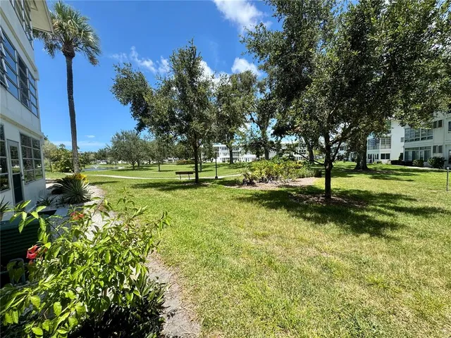 a view of a house with backyard garden and sitting area